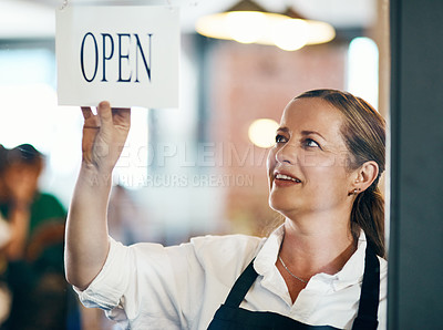 Buy stock photo Shot of a mature woman hanging up an open sign on the door of a cafe