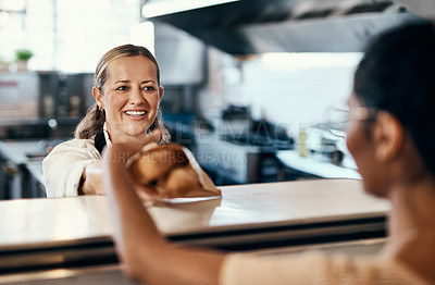 Buy stock photo Shot of a woman buying freshly made baguettes at a bakery