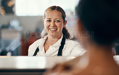 Buy stock photo Shot of a mature barista serving a customer at a cafe