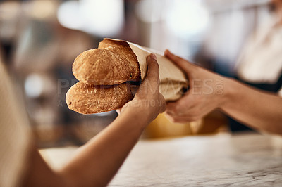 Buy stock photo Cropped shot of a woman buying freshly made baguettes at a bakery