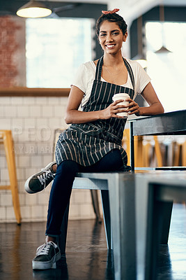 Buy stock photo Shot of a young woman drinking coffee during her break from working at cafe