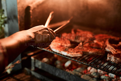 Buy stock photo Closeup shot of an unrecognisable man grilling meat while having a barbecue