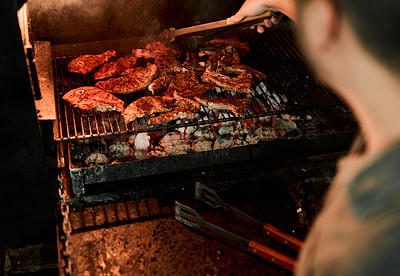 Buy stock photo Closeup shot of an unrecognisable man grilling meat while having a barbecue