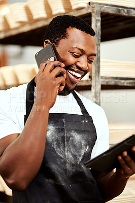 Buy stock photo Cropped shot of a male baker talking on the phone while using a digital tablet at work
