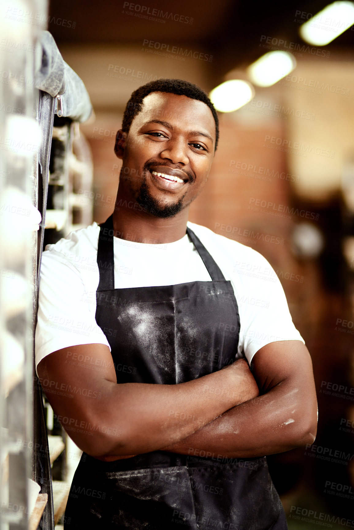 Buy stock photo Shot of a confident young man working in a bakery