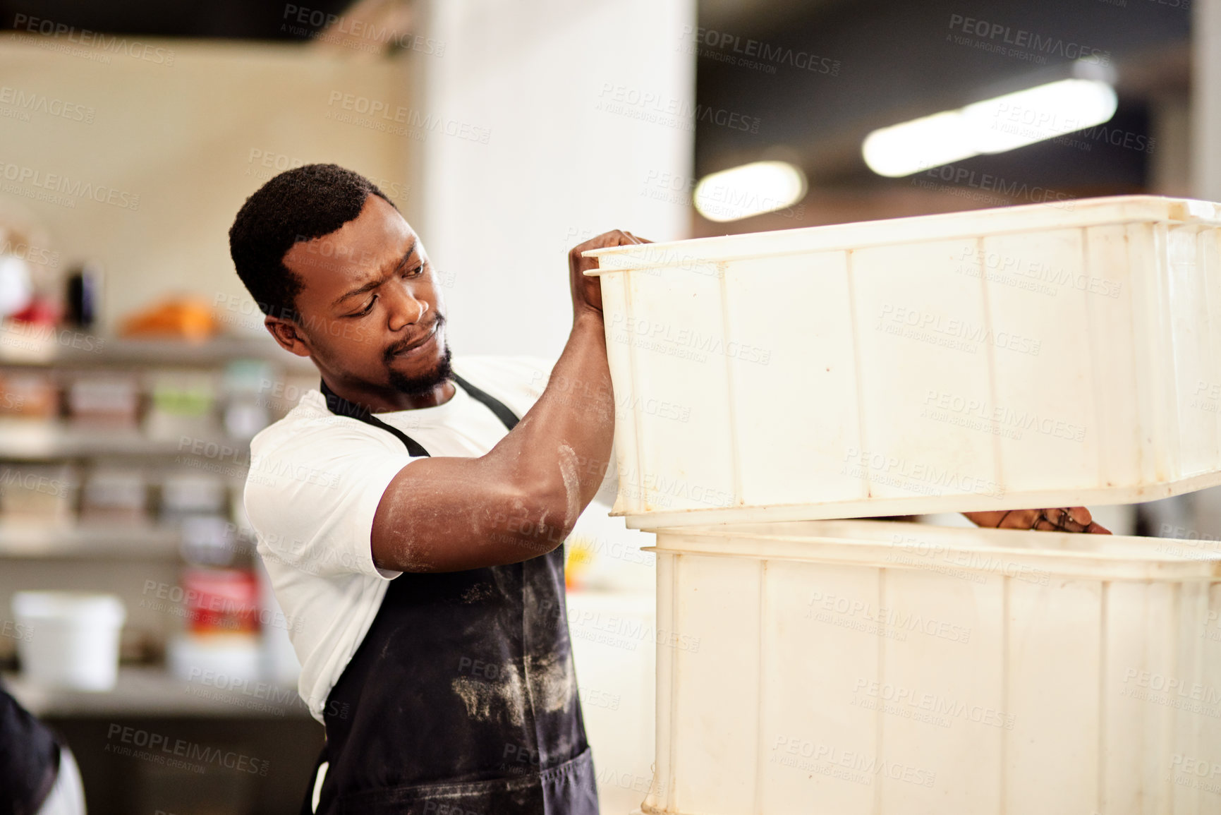 Buy stock photo Cropped shot of a young man working in a bakery