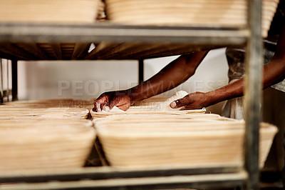 Buy stock photo Cropped shot of a male baker placing dough on a baking trolley