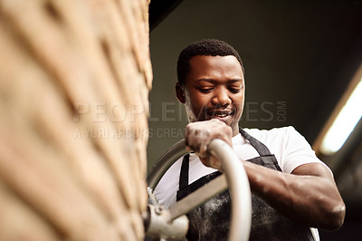 Buy stock photo Cropped shot of a male baker working in his bakery