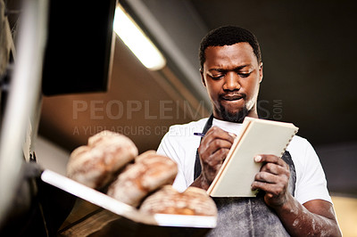 Buy stock photo Cropped shot of a male baker making notes while working in his bakery