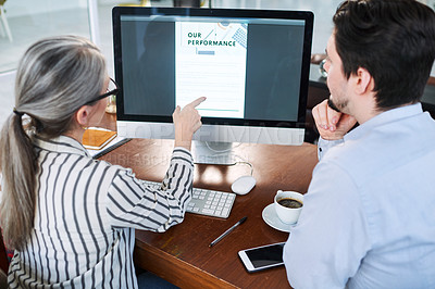 Buy stock photo Rearview shot of two businesspeople working together on a computer in an office