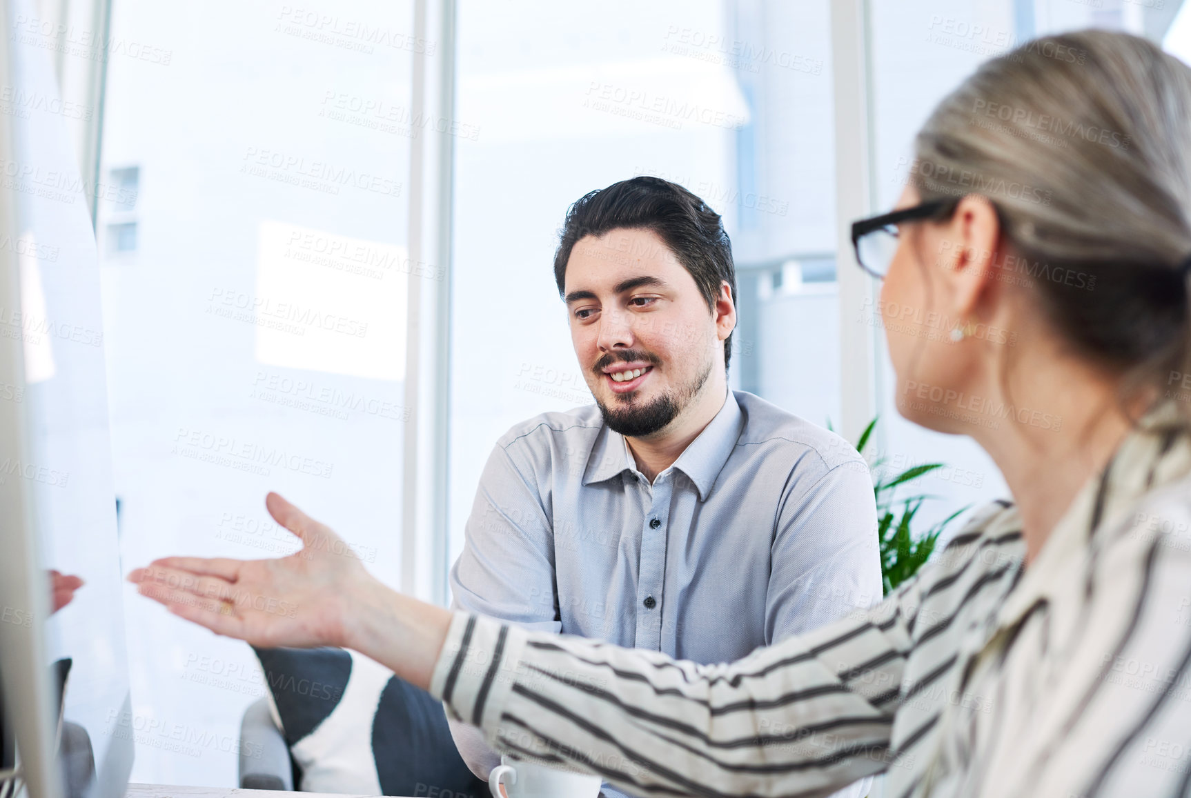 Buy stock photo Shot of two businesspeople working together on a computer in an office