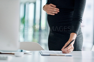 Buy stock photo Closeup shot of a pregnant businesswoman writing notes in an office
