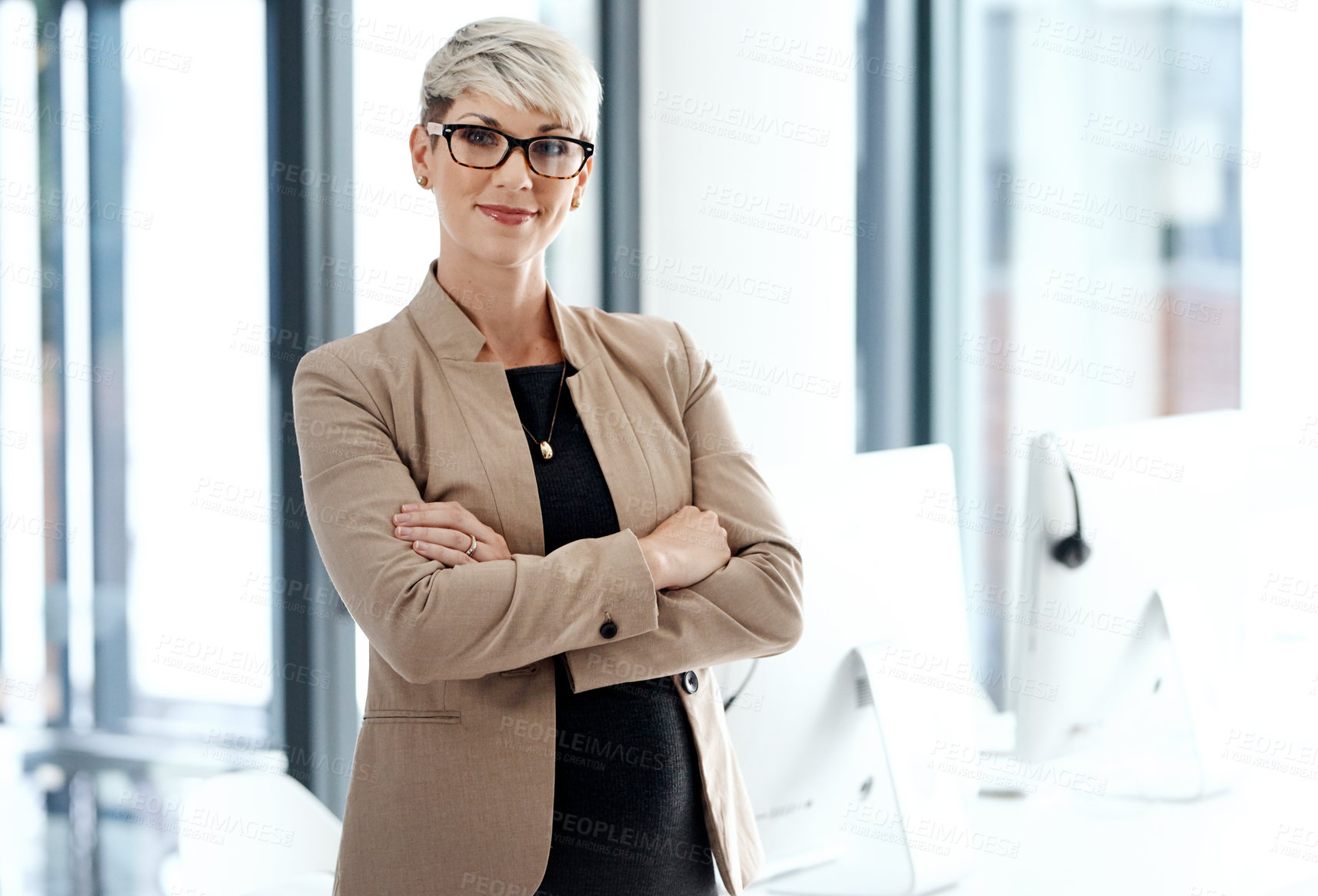 Buy stock photo Portrait of a young businesswoman standing with her arms crossed in an office