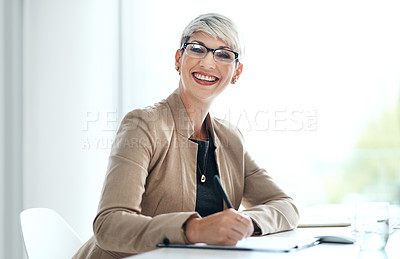 Buy stock photo Portrait of a young businesswoman writing notes in an office