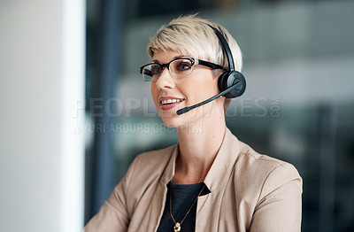 Buy stock photo Shot of a young businesswoman wearing a headset while working on a computer in an office