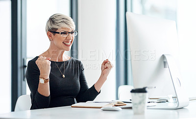 Buy stock photo Shot of a young businesswoman cheering while working on a computer in an office