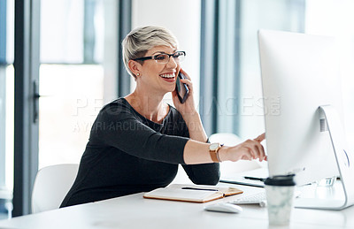 Buy stock photo Shot of a young businesswoman talking on a cellphone while working on a computer in an office