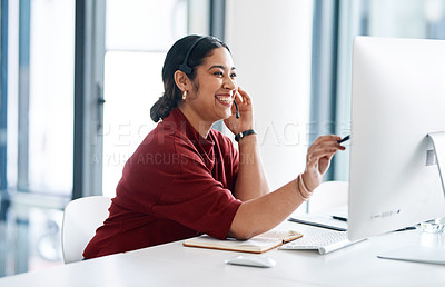 Buy stock photo Shot of a young businesswoman wearing a headset while working on a computer in an office