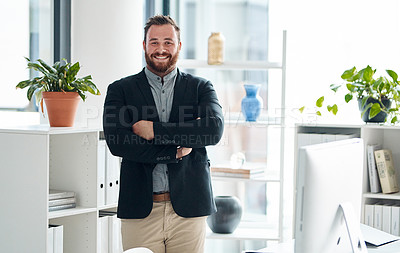 Buy stock photo Portrait of a young businessman standing with his arms crossed in an office