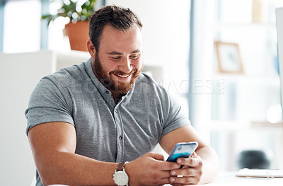 Buy stock photo Shot of a young businessman using a cellphone in an office