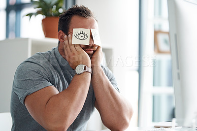 Buy stock photo Shot of a young businessman looking bored while working in an office with adhesive notes covering his eyes