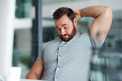 Buy stock photo Shot of a young businessman scratching his head while working in an office