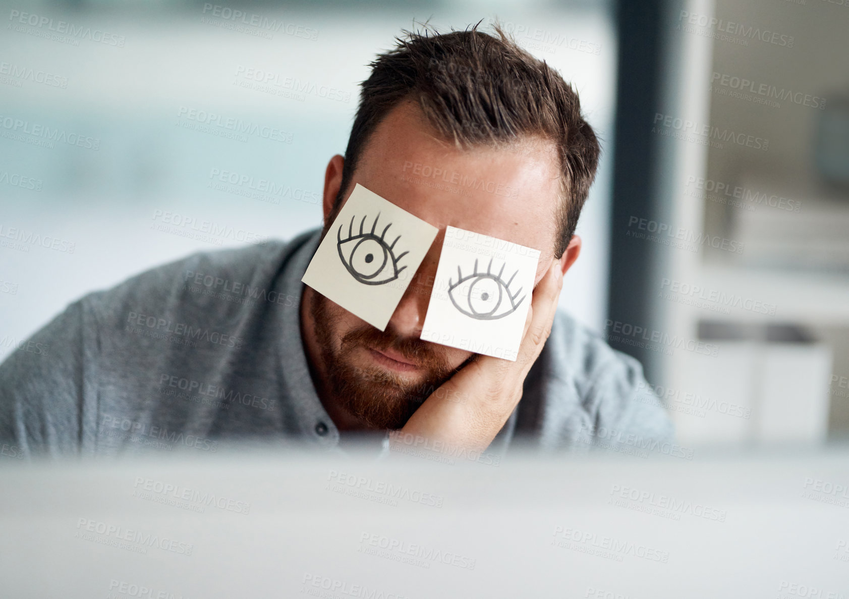 Buy stock photo Shot of a young businessman looking bored while working in an office with adhesive notes covering his eyes