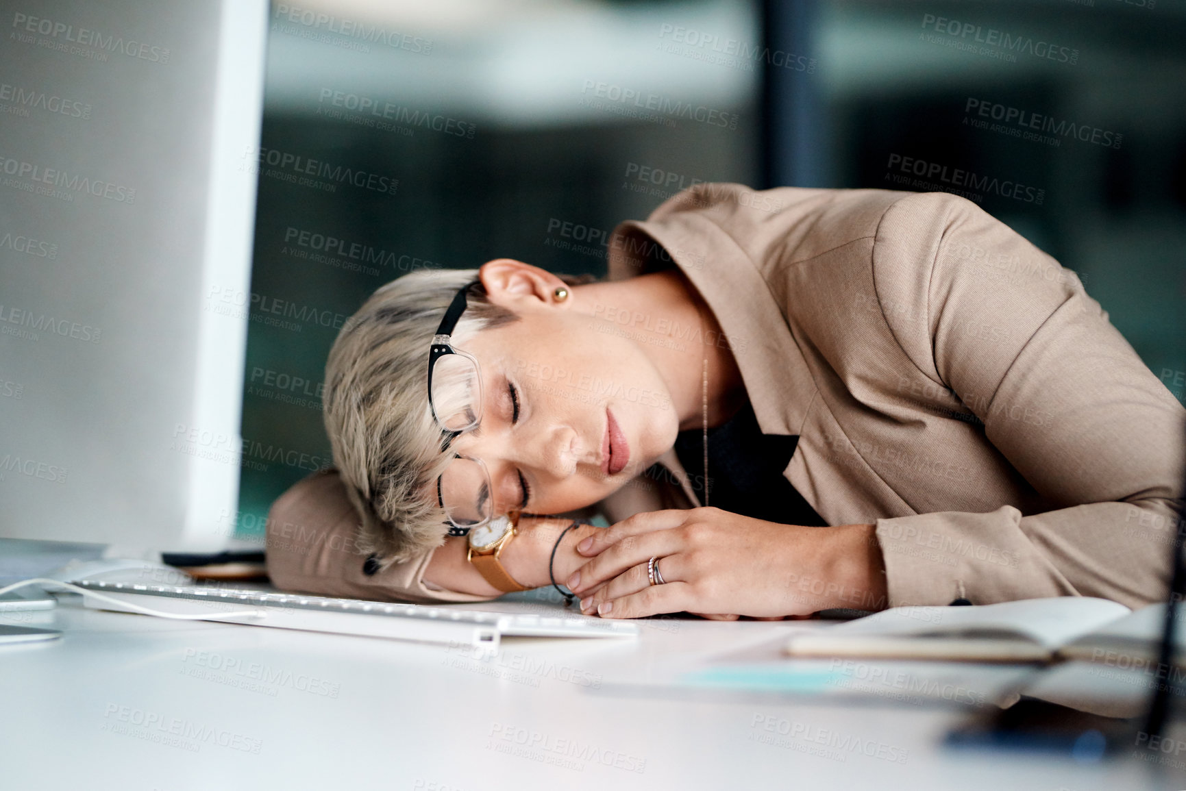 Buy stock photo Shot of a young businesswoman sleeping at a desk in an office