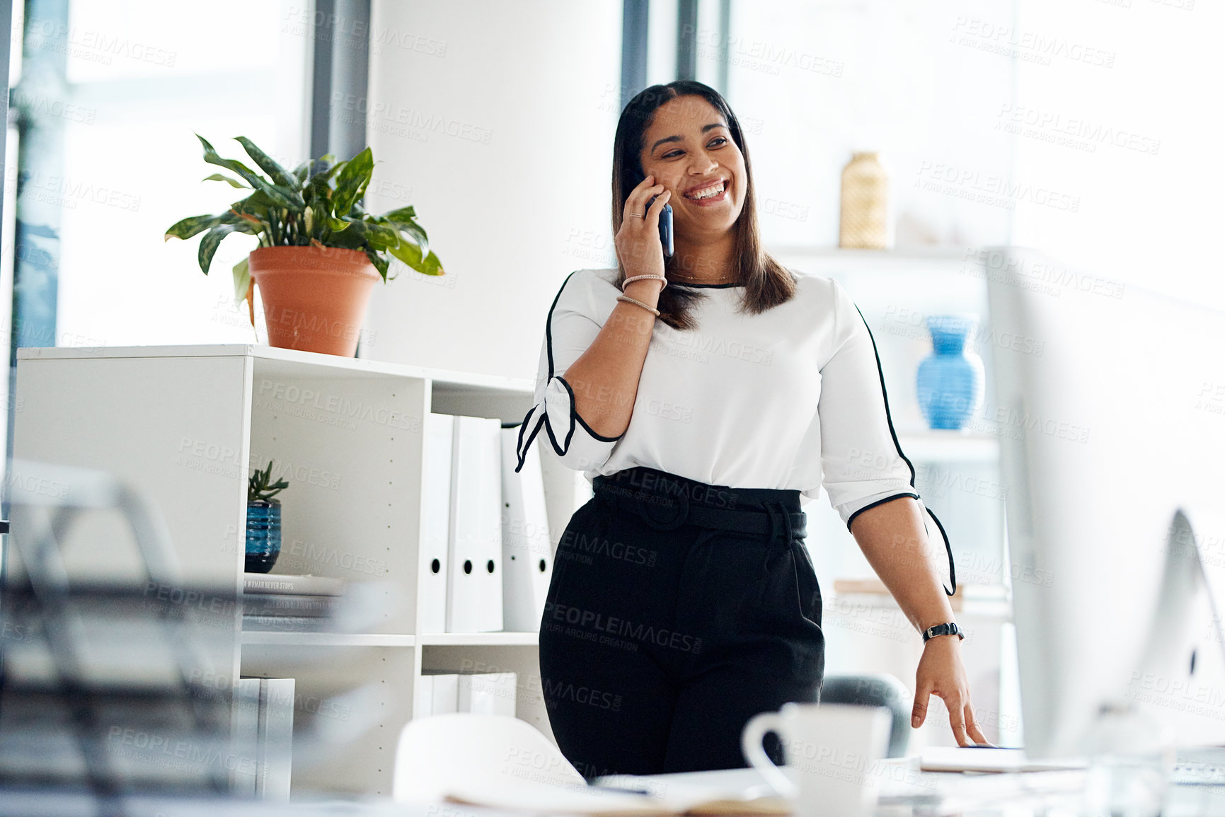 Buy stock photo Shot of a young businesswoman talking on a cellphone in an office