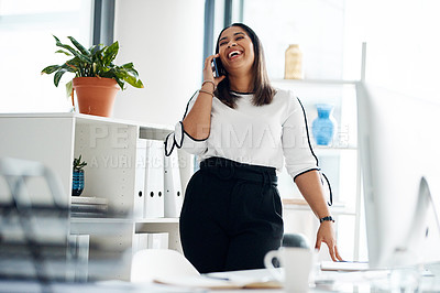 Buy stock photo Shot of a young businesswoman talking on a cellphone in an office