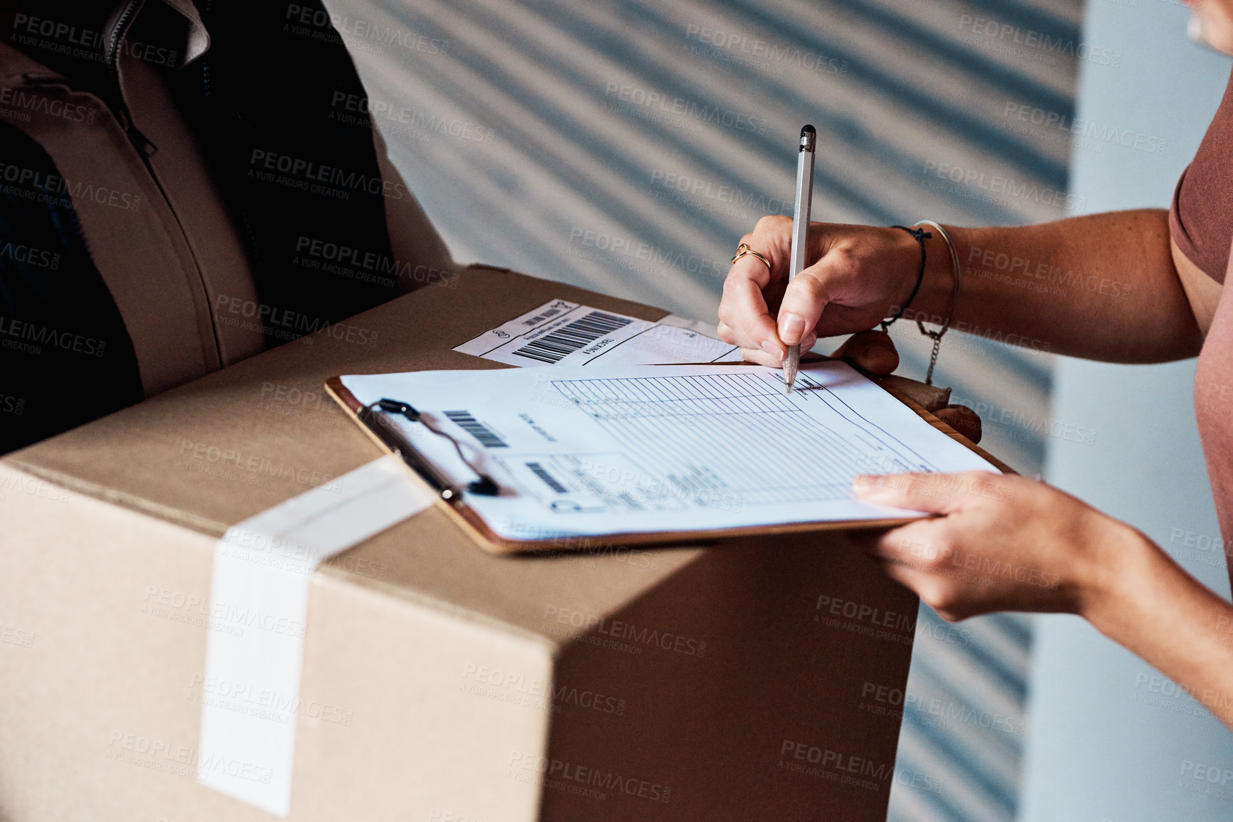 Buy stock photo Closeup shot of an unrecognisable woman signing for a delivery from the courier