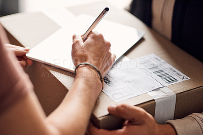 Buy stock photo Closeup shot of an unrecognisable woman using a digital tablet to sign for a delivery from the courier