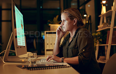 Buy stock photo Shot of a woman using her cellphone while sitting at her desk at night