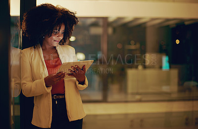 Buy stock photo Shot of a businesswoman using a digital tablet in an office at night