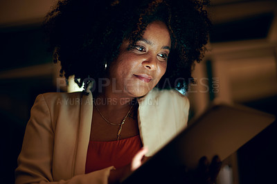 Buy stock photo Shot of a businesswoman using a digital tablet in an office at night