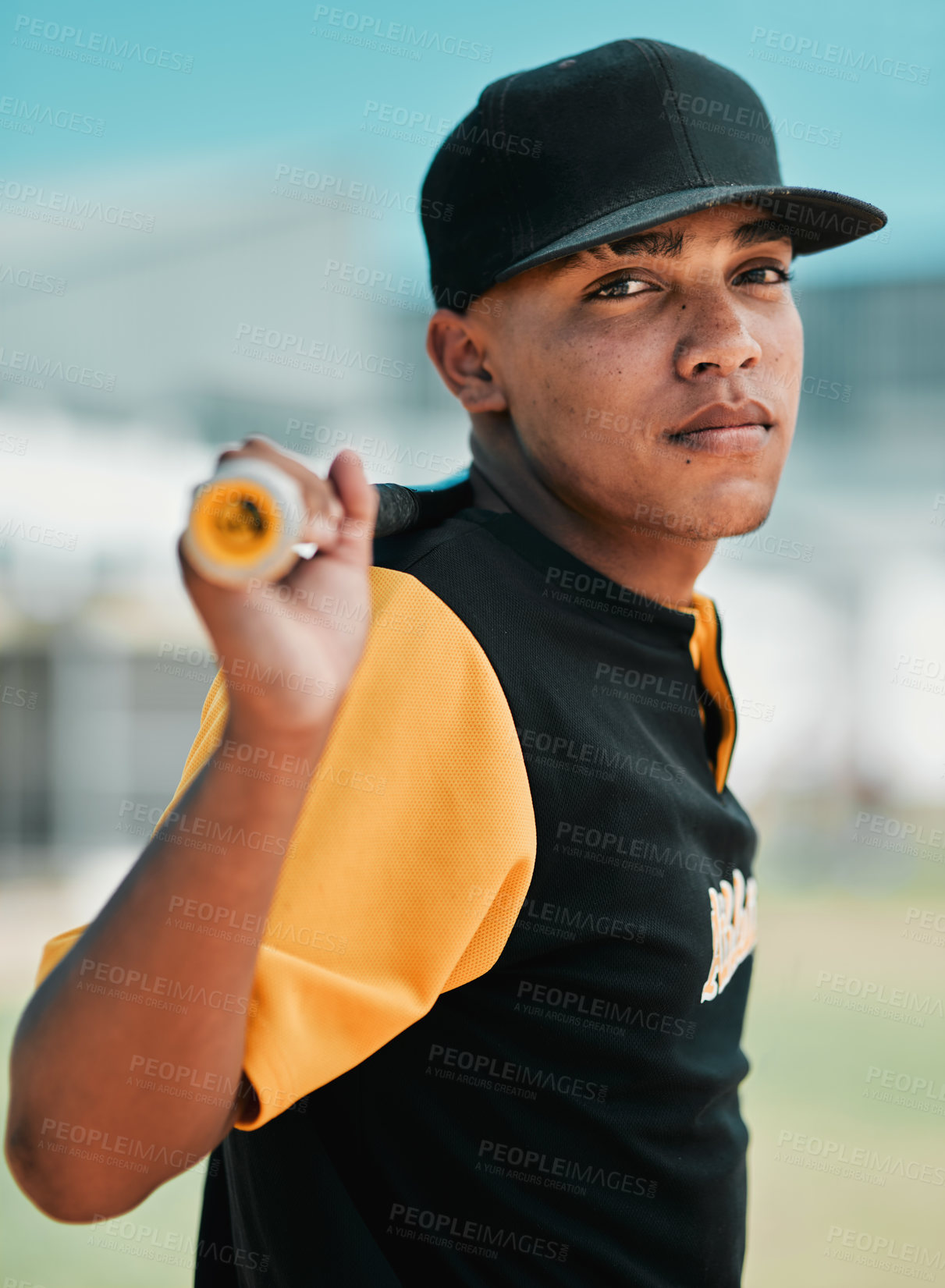 Buy stock photo Shot of a young baseball player holding a baseball bat while posing outside on the pitch