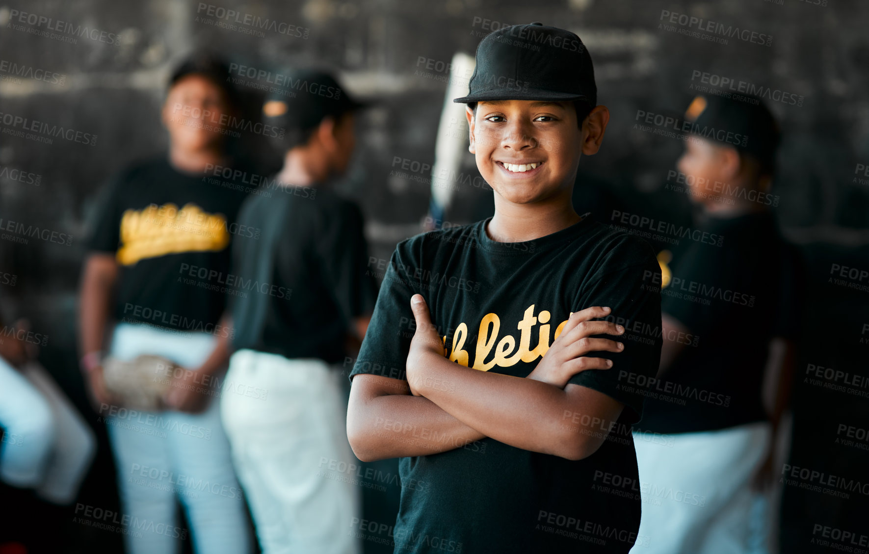 Buy stock photo Portrait of a young baseball player standing with his arms crossed with his teammates standing in the background