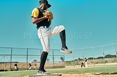 Buy stock photo shot of a young baseball player getting ready to pitch the ball during a game outdoors