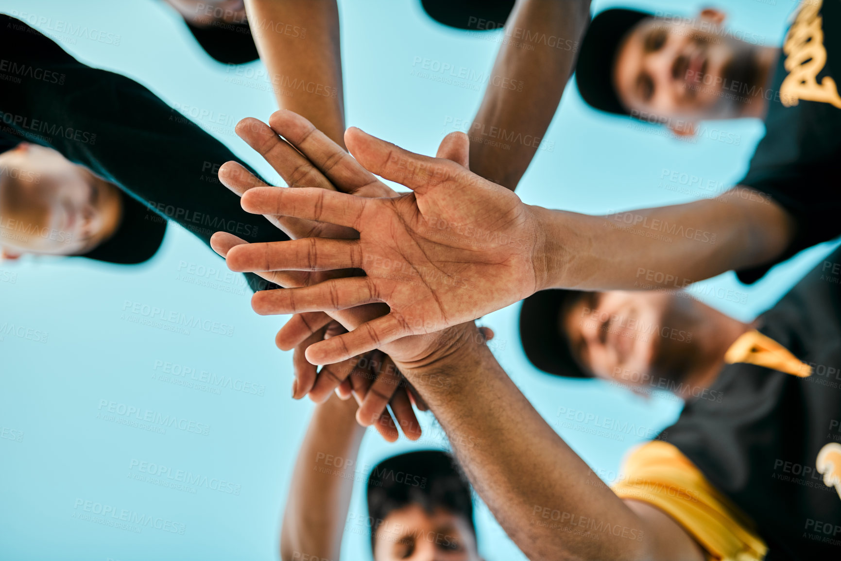 Buy stock photo Shot of a team of young baseball players joining their hands together in a huddle during a game