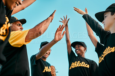 Buy stock photo Shot of a team of young baseball players joining their hands together in a huddle during a game