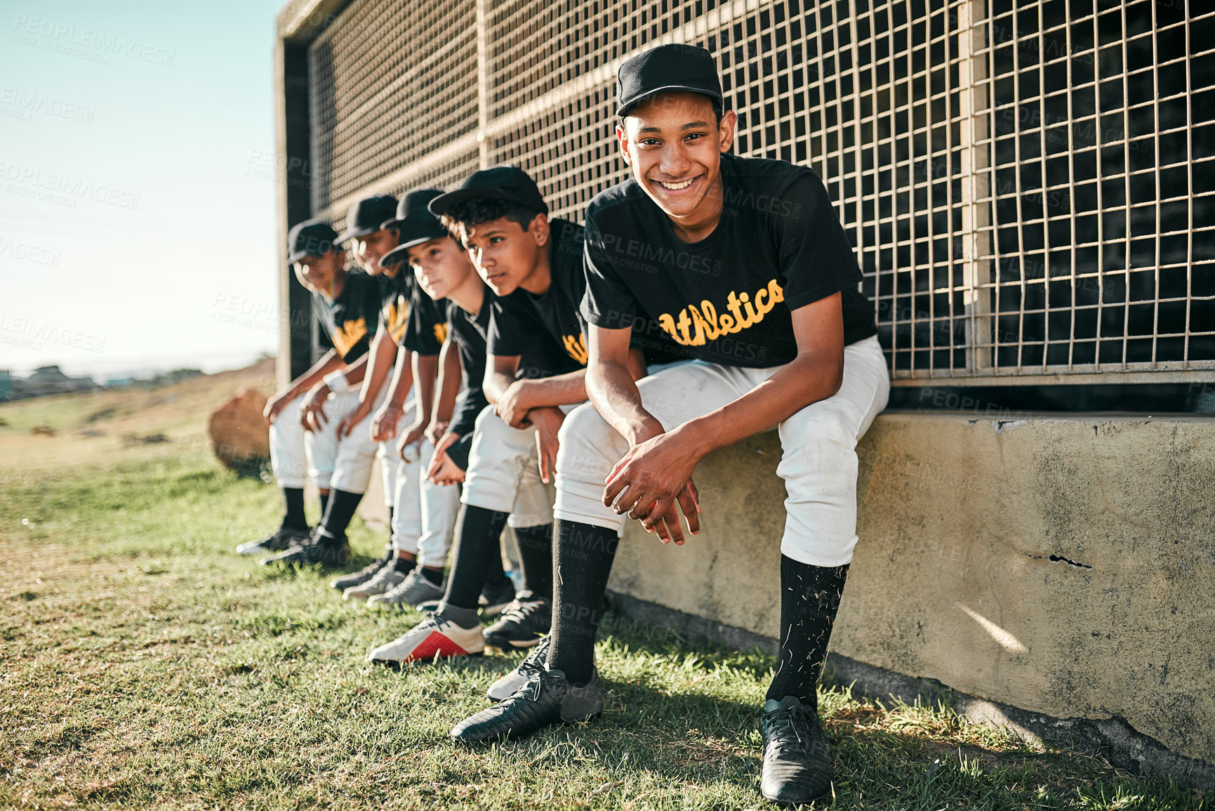Buy stock photo Shot of a group of baseball players sitting together on a field