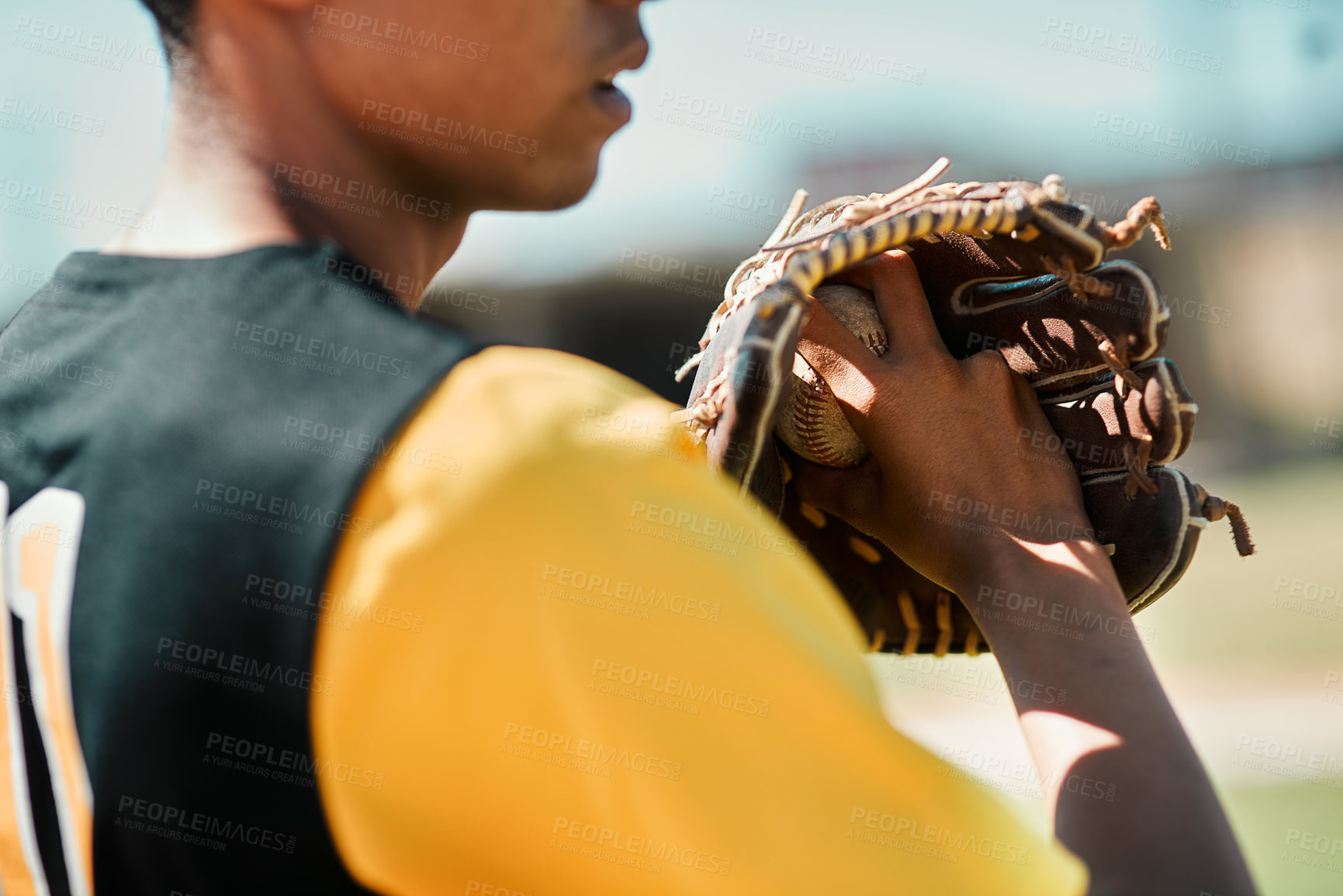 Buy stock photo Shot of a young baseball player getting ready to pitch the ball during a game outdoors
