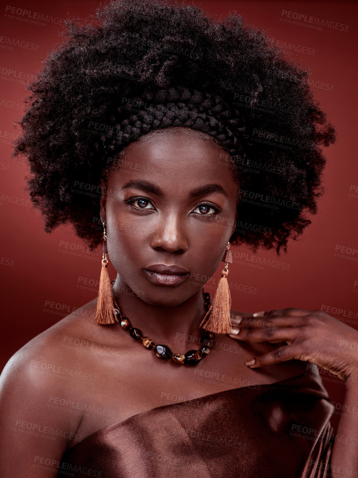 Buy stock photo Beauty, portrait and black woman with fashion in studio isolated on a red background. Face, makeup cosmetics and serious African female model with stylish outfit, traditional earings and jewelry.