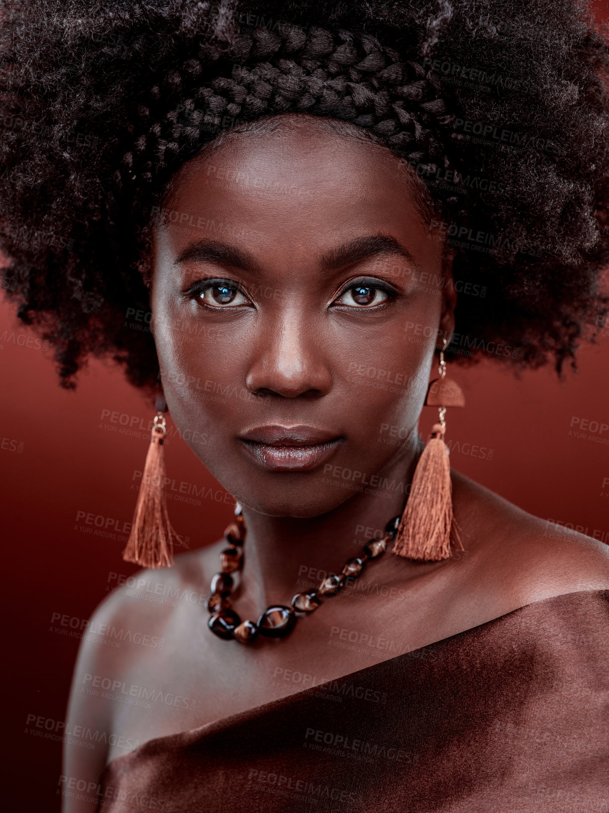 Buy stock photo Face, portrait and black woman with fashion in studio isolated on a red background. Natural beauty, makeup cosmetics and serious African model with stylish outfit, traditional jewelry and culture.