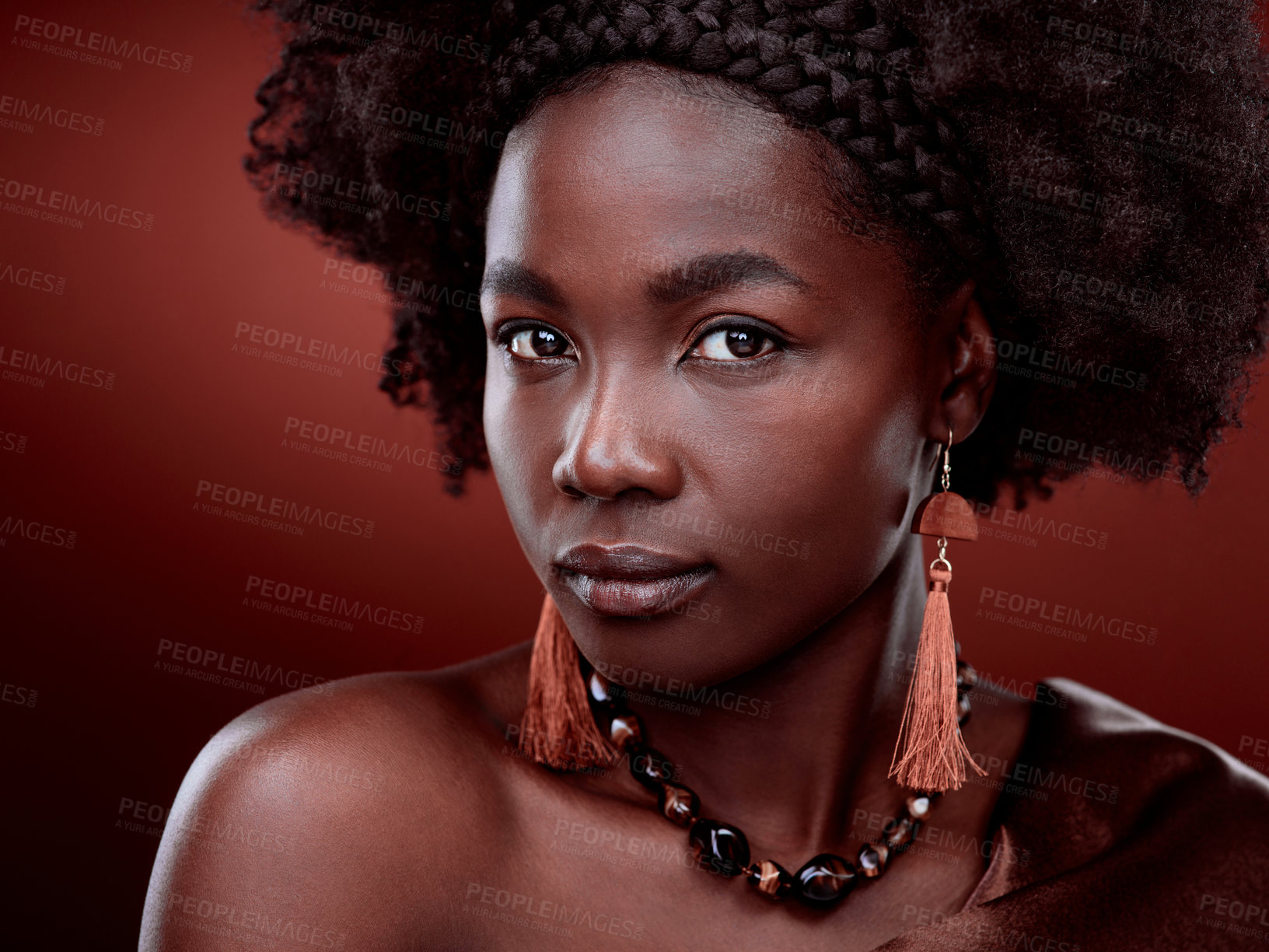 Buy stock photo Cropped portrait of a beautiful young woman posing against a red background