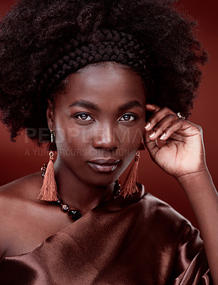 Buy stock photo Portrait, natural beauty and black woman with fashion in studio isolated on a red background. Face, makeup cosmetics and confident African model with stylish outfit, traditional jewelry and culture.