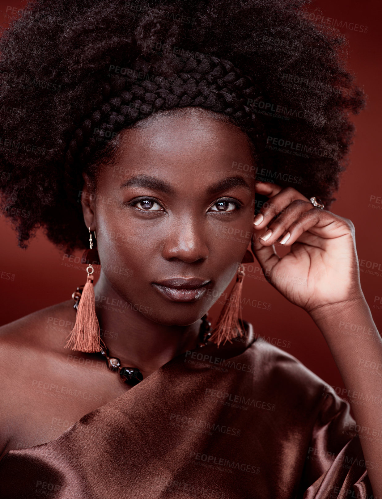 Buy stock photo Portrait, natural beauty and black woman with fashion in studio isolated on a red background. Face, makeup cosmetics and confident African model with stylish outfit, traditional jewelry and culture.