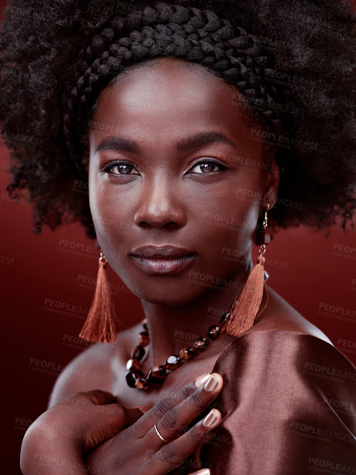 Buy stock photo Natural beauty, portrait and black woman with fashion in studio isolated on a red background. Face, makeup cosmetics and serious African model with stylish outfit, traditional jewelry or aesthetic.