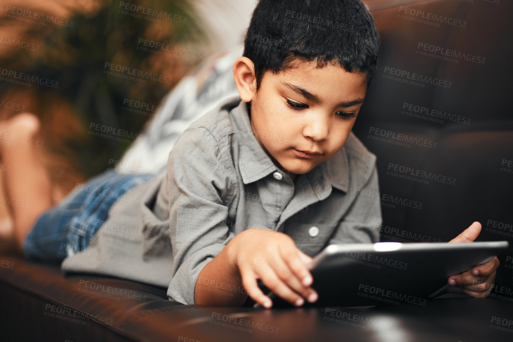 Buy stock photo Child, tablet and internet on sofa for games or movies, streaming and digital app in home. Website, boy or kid and technology or online for videos, education and multimedia in lounge or living room