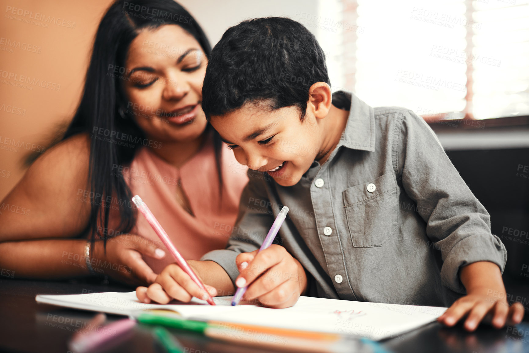 Buy stock photo Shot of an adorable little boy colouring in with his mother at home
